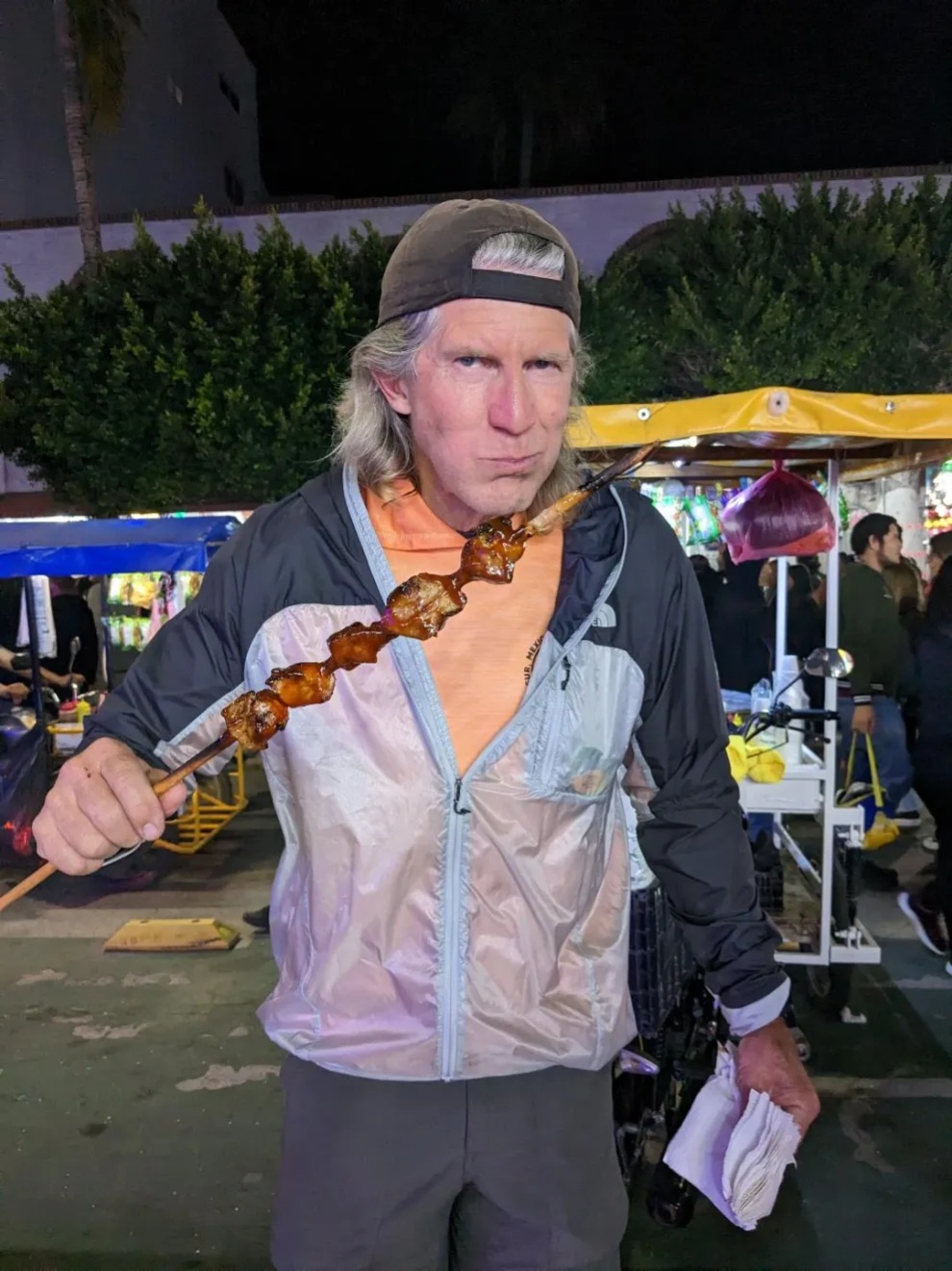 Kevin eating street meat on a spear